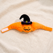 The bonnet laid flat showing the velcro tab, embroidered face and the witch hat