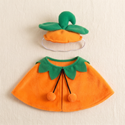The cap and cape set laid flat, cap with its green stem and two leaves above the orange cape