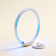 The glow collar standing upright on a warm ivory studio backdrop, LED points lit blue, USB cable coiled beside it